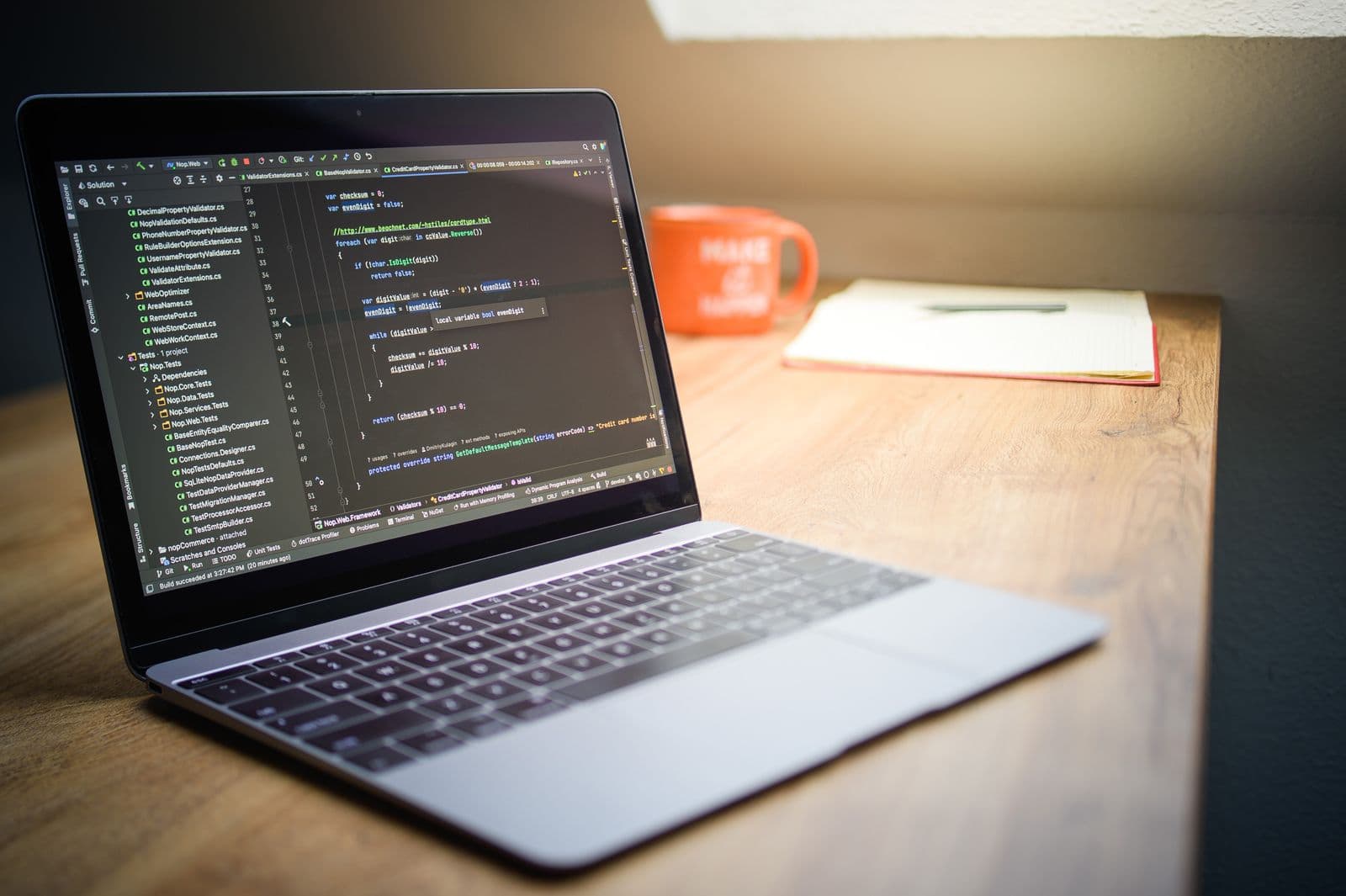 Laptop mit C#-Quellcode auf einem Schreibtisch
